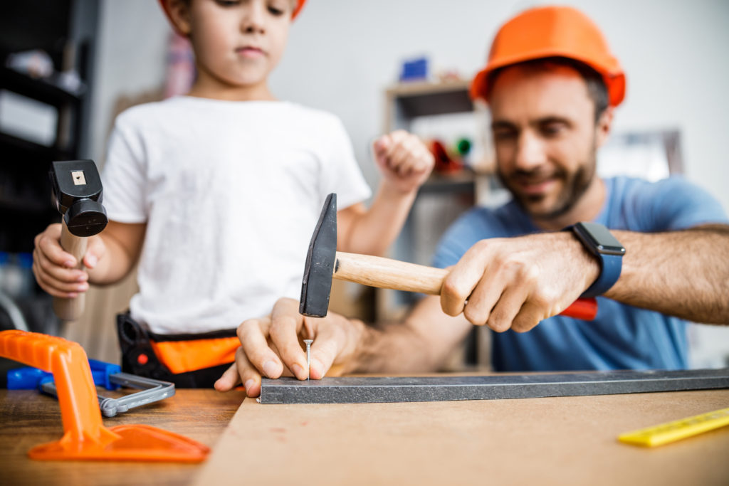 Bild von Vater und Sohn, die gemeinsam werken mit Hammer und Nagel